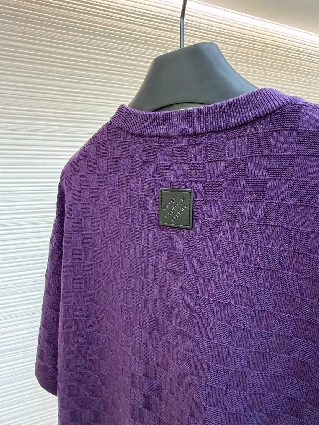 LOUIS VUITTON letter embroidered dark checkerboard jacquard short sleeves ●Original version: Purchased and developed at 9350 ●Item number: 1682319-B00 ●Fabric: 100% cotton ●Technology: jacquard knitting ●Color: Purple ●Version: Fitted version ●Weight: about 340 grams ●Size: S-M-L-XL ●Description: This Louis Vuitton purple knitted short-sleeve is made of custom worsted wool blended fabric. It is created with an 18-needle high-density weaving process using a computerized flat knitting machine to create a three-dimensional checkerboard texture. The checkered pattern is laser positioned and patterned. The size and spacing of each grid are accurate to 0.1 cm, showing a regular relief texture. The left chest uses same-color inlay embroidery technology, and the "LVM SINCE 1854" logo is embroidered with a high density of 1200 stitches/square centimeter. The embroidery thread is made of high-elastic mercerized cotton thread of the same color as the body, forming a natural texture layer with the knitted base. The neckline adopts seamless cylindrical rib technology, which is not easy to loose after high-temperature shaping treatment. The shoulders are made of seamless bonding technology to reduce the abruptness of the seams. The overall micro-profile tailoring combined with the invisible stitching technology of the side seams not only ensures the comfort of wearing, but also makes the body lines smoother. Each process has undergone multiple quality control tests by the brand to ensure the quality and durability of the craftsmanship. The overall wiring is straight and delicate, the fabric is comfortable and soft, and the color is consistent without color difference. It can be matched with the same style to create a fashionable look and control various occasions. Customized accessories, complete with three standards, same style for men and women!